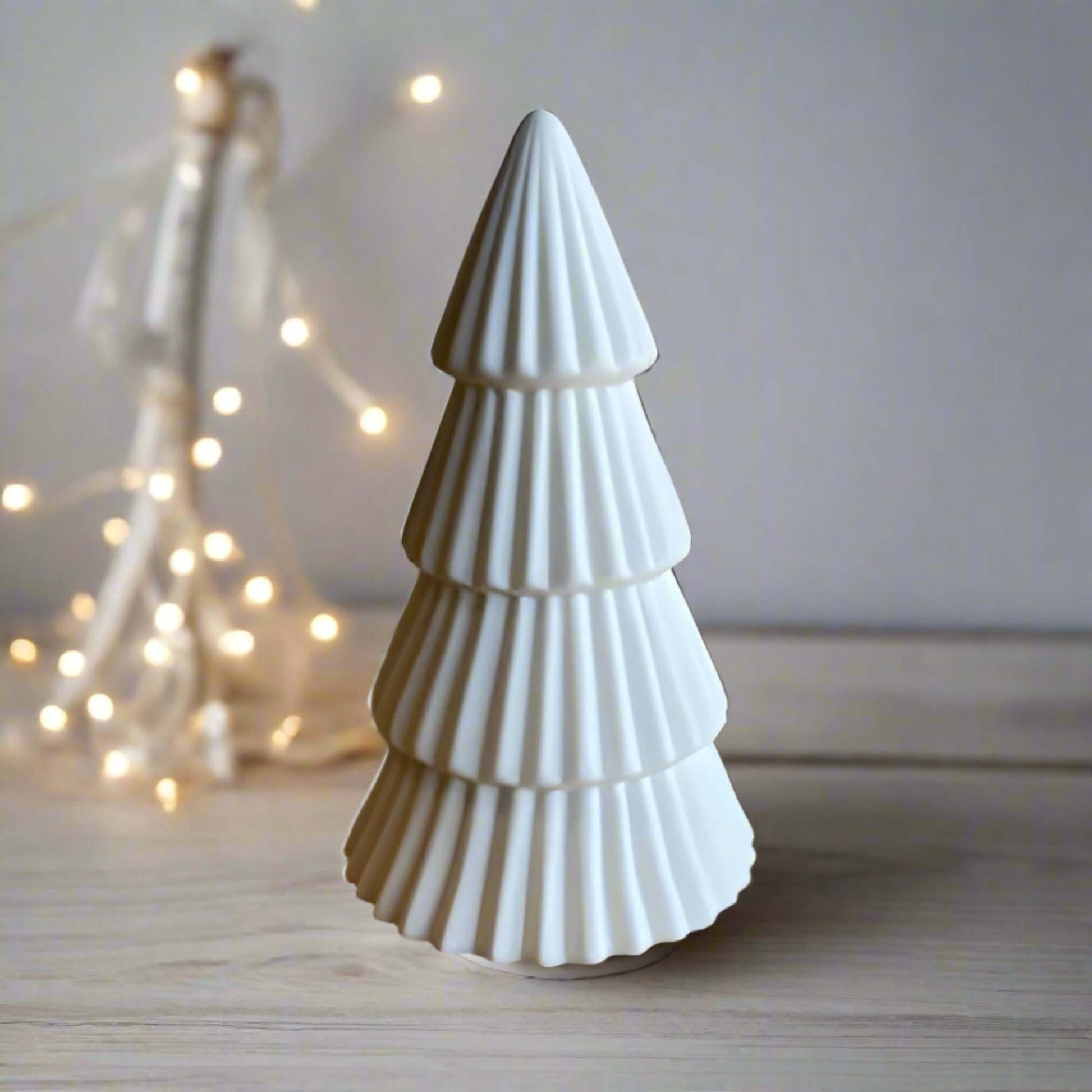 Christmas tree light-up ornament, A charming ceramic white tree ornament, featuring a matte finish and ridged detailing. Comes complete with LED lights, perfect for creating a warm and cosy ambiance for any home space. Available to purchase in two sizes: 