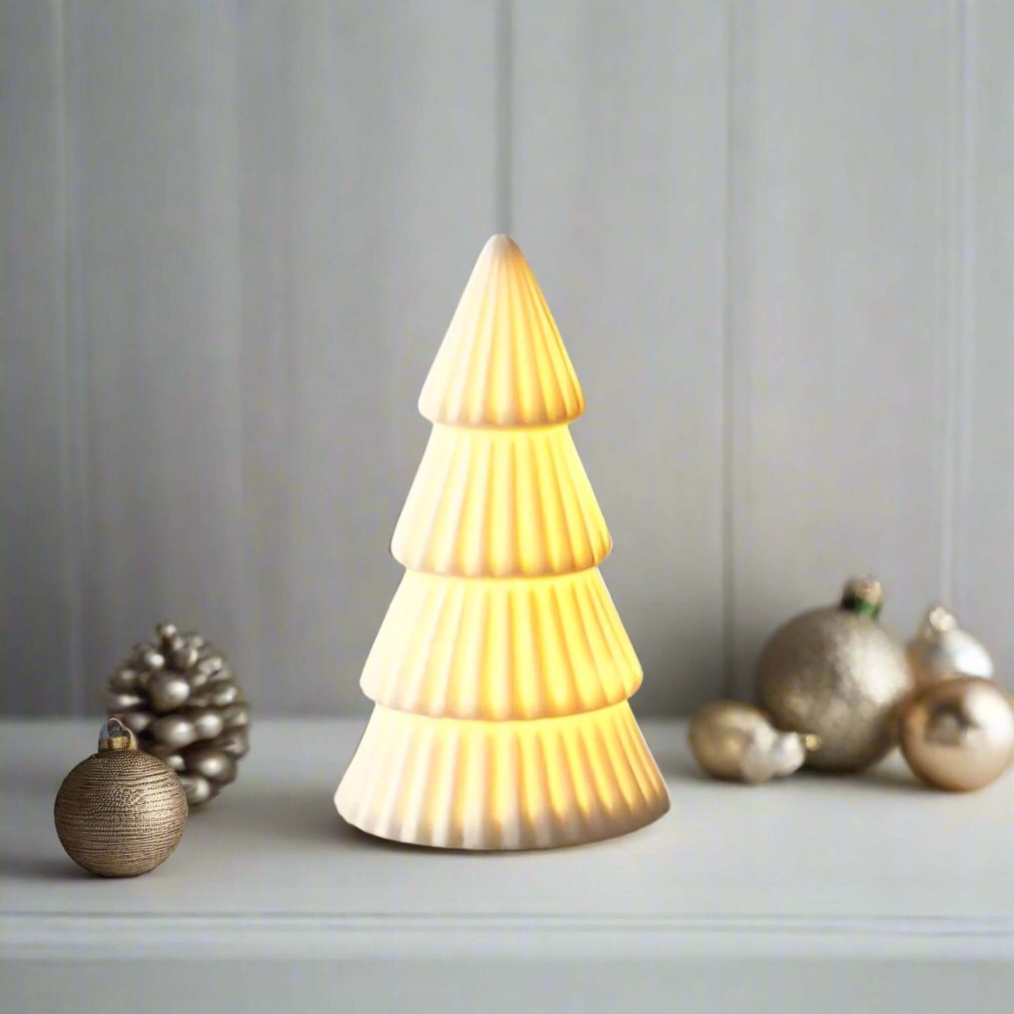 Christmas tree light-up ornament, A charming ceramic white tree ornament, featuring a matte finish and ridged detailing. Comes complete with LED lights, perfect for creating a warm and cosy ambiance for any home space. Available to purchase in two sizes: 